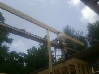 Carpenter setting a ridge beam over a new addition frame — Ice Dam Removal by Roofing Brothers in Flemingsburg
