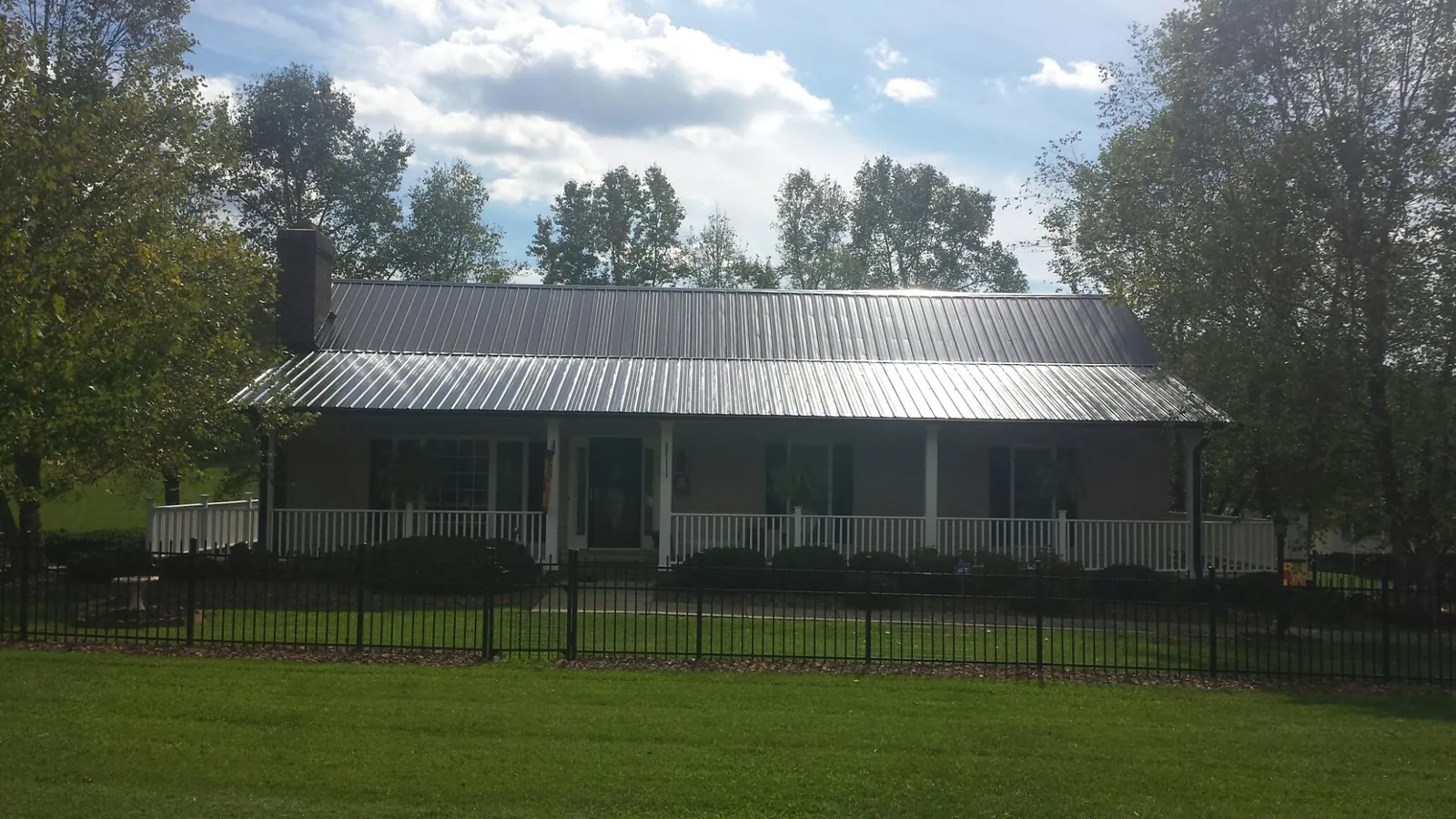 Gray metal roof on a brick ranch with a full width front porch — Gutter Guard Installation work by our crew in Flemingsburg